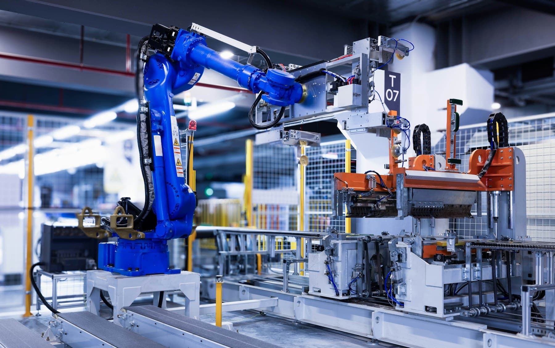 Blue industrial robot arm operating on a factory production line
