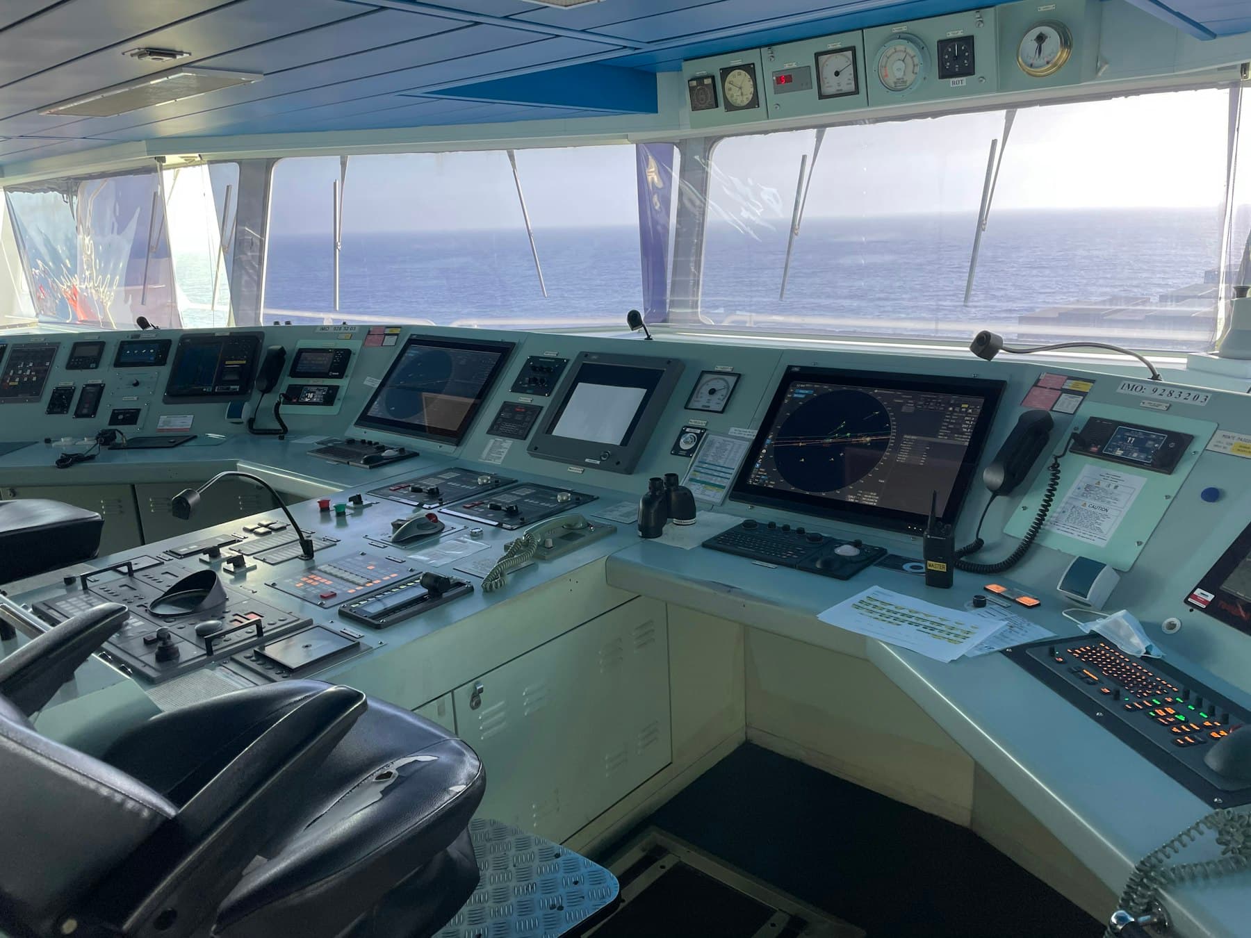 The control room of a ship with multiple monitors