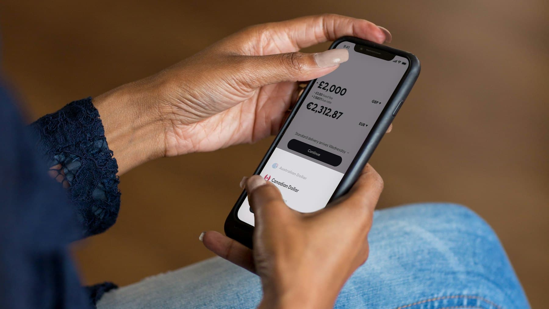 Hands holding a smartphone using a banking app to transfer money