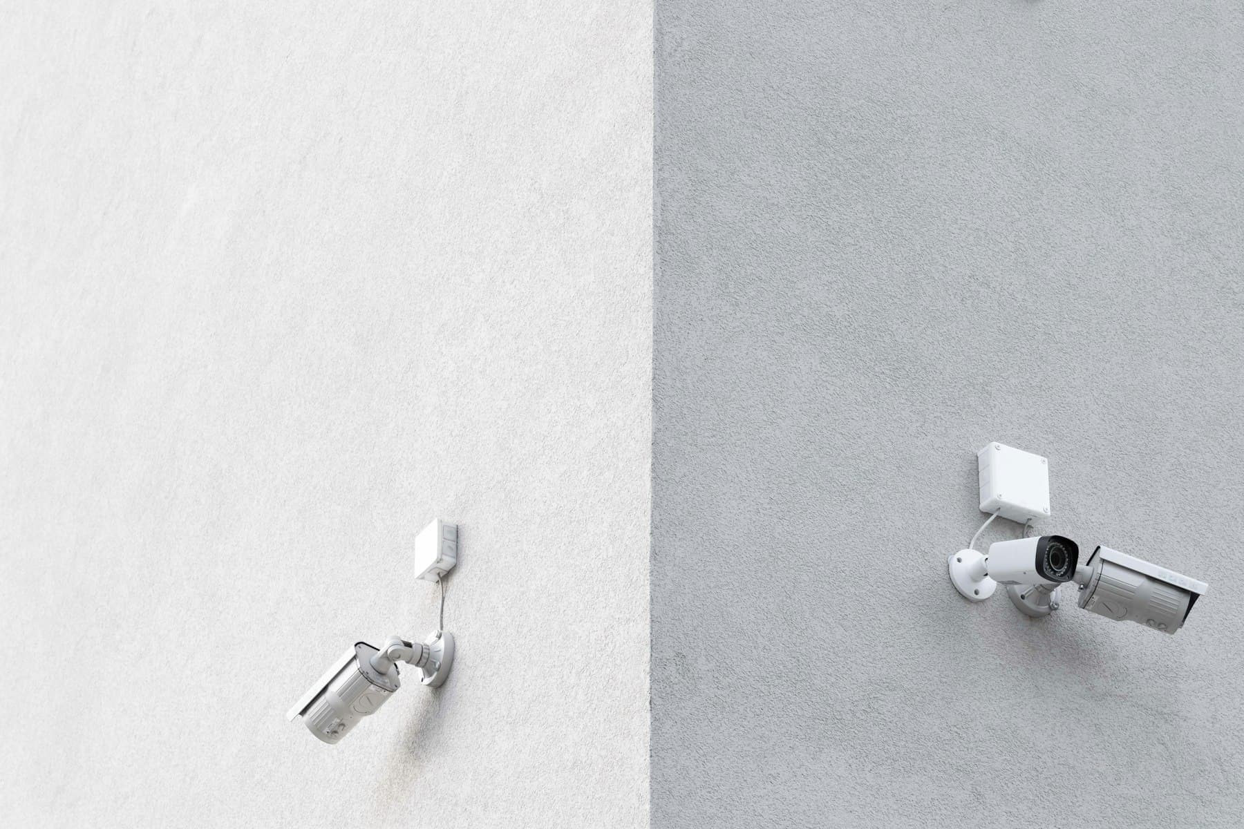 Three white CCTV cameras mounted on a wall