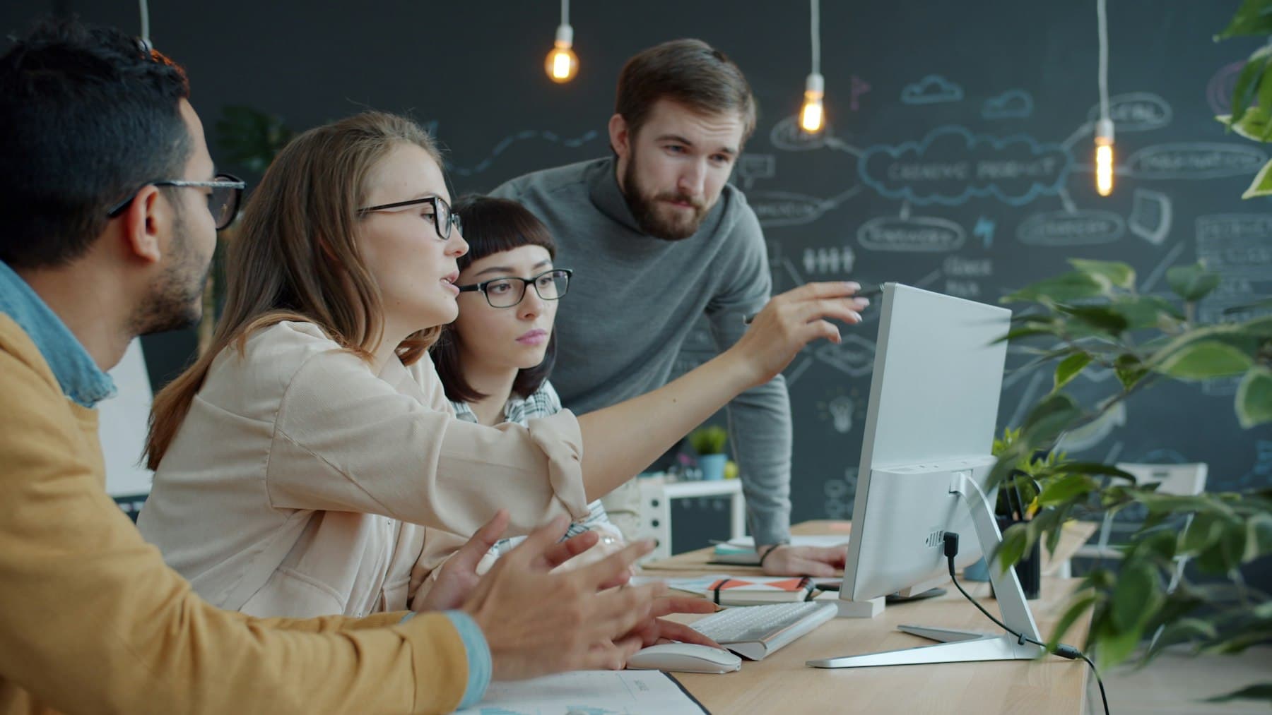 Team collaborating around a computer in an office