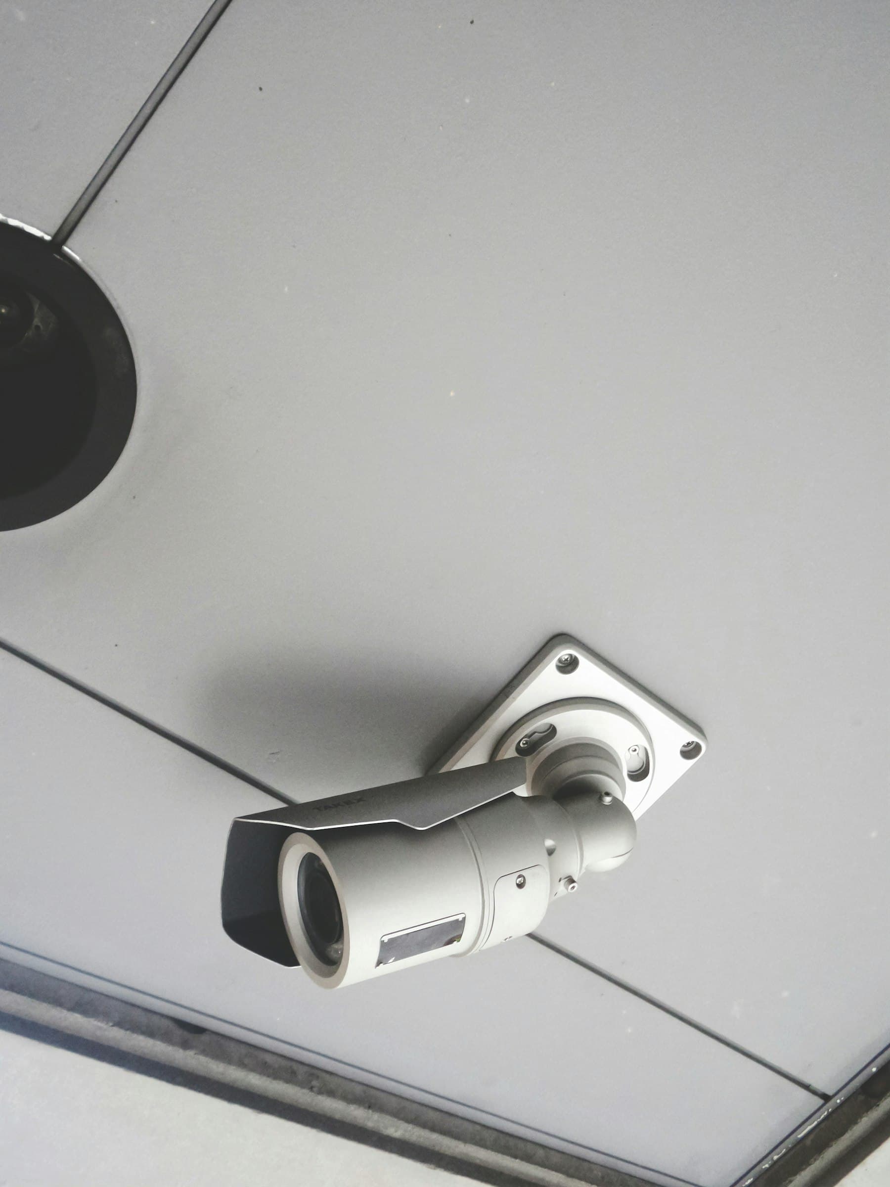 A security camera mounted to the ceiling of a building