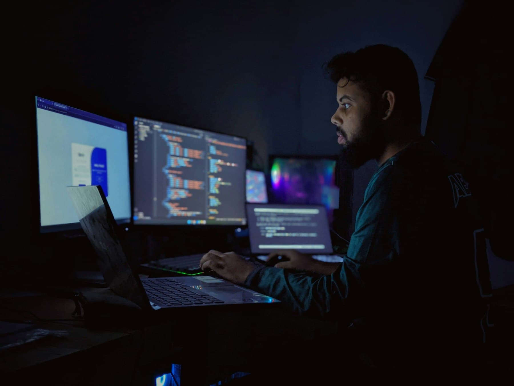 Developer working across three monitors displaying code